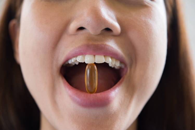 The woman takes essential vitamins for gums and teeth everyday