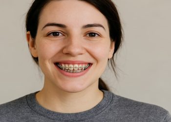 Smiling woman with metal braces showcasing braces cost in canada.